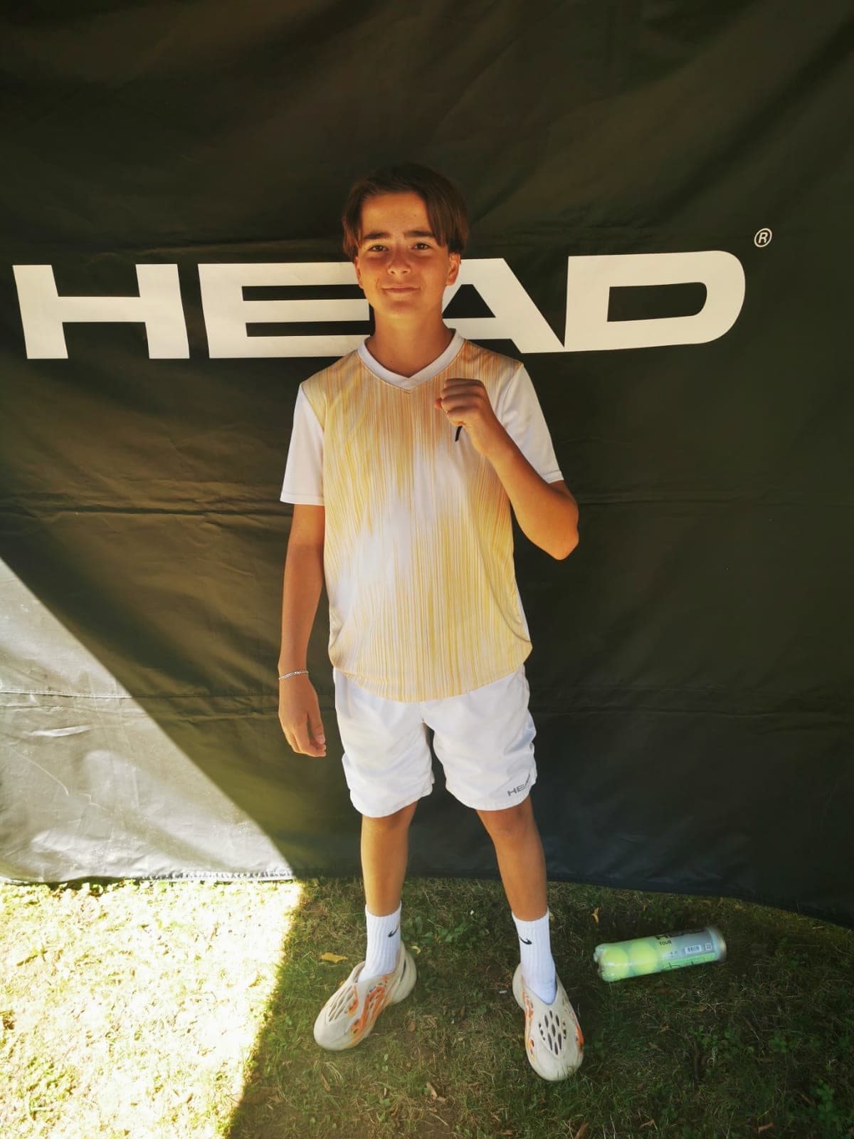 Lenart Kadriu, portrait en tenue de match devant une bâche HEAD